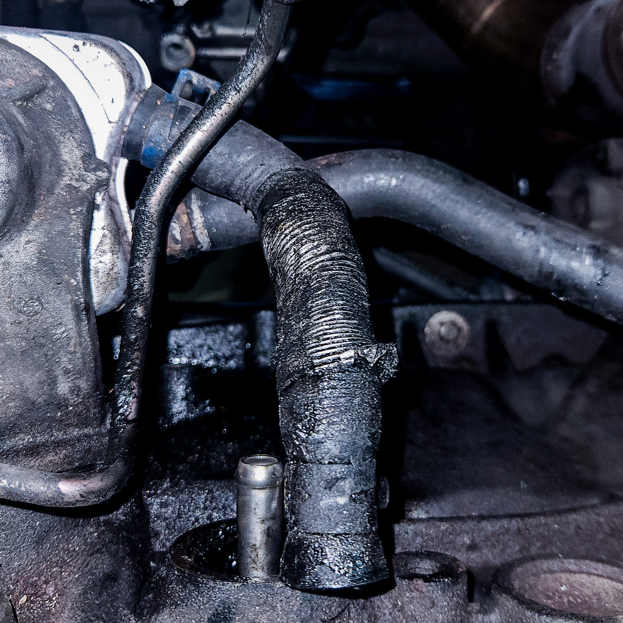 Alter Wasserschlauch zum Ölkühler im VW T4 Alter Wasserschlauch zum Ölkühler im Motorraum eines VW T4